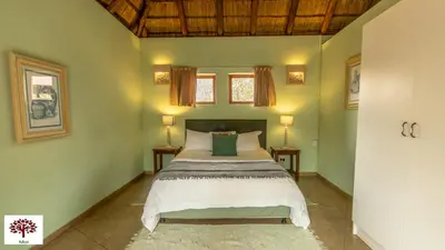a bedroom with a bed and two windows at Zebula Golf and Wildlife Estate - Walk of the Eland Pax 12 - Moi Signature Luxury villa in Mabula