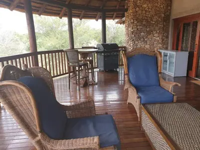 a porch with wicker chairs and a table on a deck at Zebula Golf and Wildlife Estate - Great Heights Pax 16 - Moi Signature Luxury villa in Mabula