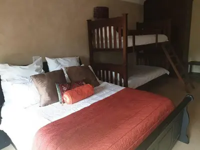 a bedroom with a bed and two bunk beds at Zebula Golf and Wildlife Estate - Great Heights Pax 16 - Moi Signature Luxury villa in Mabula