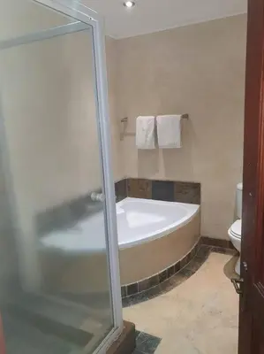 a bathroom with a bath tub and a toilet at Zebula Golf and Wildlife Estate - Great Heights Pax 16 - Moi Signature Luxury villa in Mabula