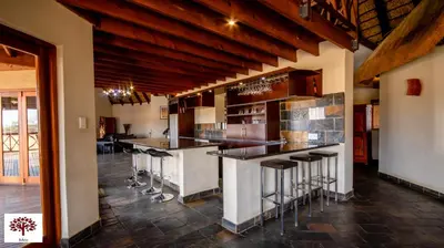 a kitchen with a bar with stools at Zebula Golf and Wildlife Estate - Open Horizon Pax 8 - Moi Signature Luxury villa in Mabula