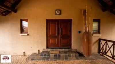a house with a wooden door and some stairs at Zebula Golf and Wildlife Estate - Open Horizon Pax 8 - Moi Signature Luxury villa in Mabula