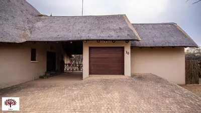 a building with a garage door with a roof at Zebula Golf and Wildlife Estate - Open Horizon Pax 8 - Moi Signature Luxury villa in Mabula