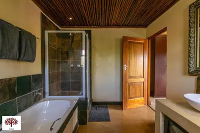 a bathroom with a bath tub and a sink at Zebula Golf and Wildlife Estate - Aardwolf Pax 10 - Moi Signature Luxury villa in Mabula