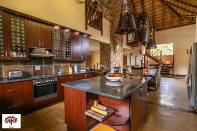 a large kitchen with wooden cabinets and a counter top at Zebula Golf and Wildlife Estate - Aardwolf Pax 10 - Moi Signature Luxury villa in Mabula