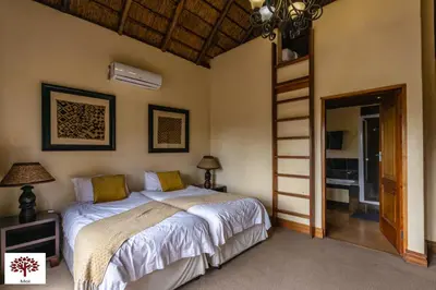 a bedroom with a bed and a ladder in it at Zebula Golf and Wildlife Estate - Aardwolf Pax 10 - Moi Signature Luxury villa in Mabula