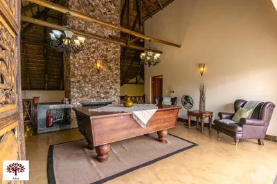 a large living room with a table and a couch at Zebula Golf and Wildlife Estate - Aardwolf Pax 10 - Moi Signature Luxury villa in Mabula