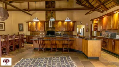 a large kitchen with wooden cabinets and a large island at Zebula Golf and Wildlife Estate - Oryx Walkway Pax 16 - Moi Signature Luxury villa in Mabula