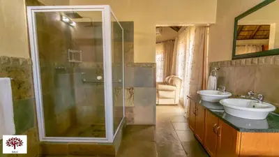 a bathroom with a shower and a sink at Zebula Golf and Wildlife Estate - Oryx Walkway Pax 16 - Moi Signature Luxury villa in Mabula