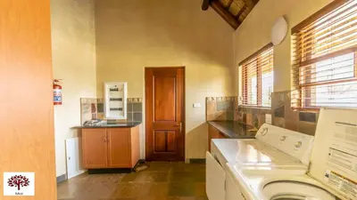 a laundry room with a washing machine and a door at Zebula Golf and Wildlife Estate - Oryx Walkway Pax 16 - Moi Signature Luxury villa in Mabula