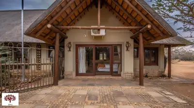 a small house with a large glass door at Zebula Golf and Wildlife Estate - Oryx Walkway Pax 16 - Moi Signature Luxury villa in Mabula