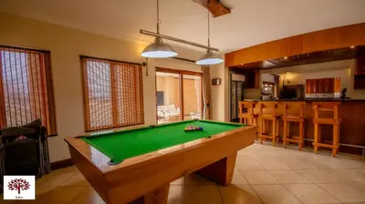 a kitchen with a pool table in a room at Zebula Golf and Wildlife Estate - Owl's Haven Pax 10 - Moi Signature Luxury villa in Mabula