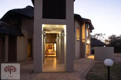 a hallway of a house with the light shining on it at Zebula Golf and Wildlife Estate - Owl's Haven Pax 10 - Moi Signature Luxury villa in Mabula