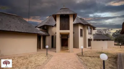 a building with a clock tower in a courtyard at Zebula Golf and Wildlife Estate - Owl's Haven Pax 10 - Moi Signature Luxury villa in Mabula