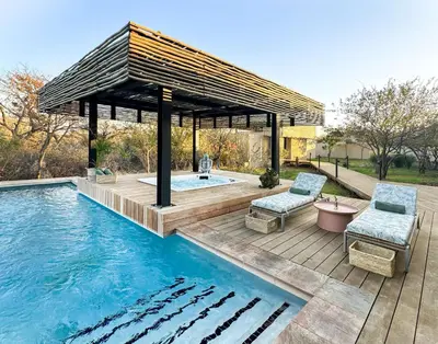 a pool with a gazebo and two chairs next to it at Radisson Safari Hotel Hoedspruit in Hoedspruit