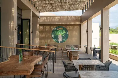 a restaurant with tables and chairs and a sign on the wall at Radisson Safari Hotel Hoedspruit in Hoedspruit