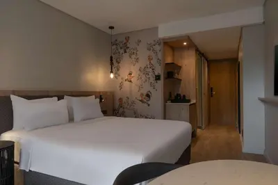 a bedroom with a large white bed and a table at Radisson Safari Hotel Hoedspruit in Hoedspruit