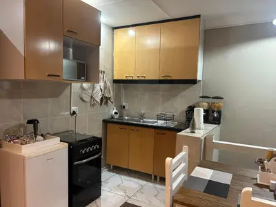 a kitchen with wooden cabinets and a stove top oven at Villa La Sola B&B and Self-Catering in Boksburg
