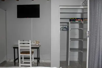 a dining room with a table and a tv in a room at Villa La Sola B&B and Self-Catering in Boksburg