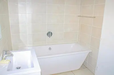 a bathroom with a white tub and a sink at The Blyde Holiday beach in Pretoria