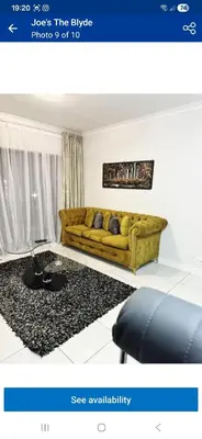 a living room with a yellow couch and a black rug at The Blyde Holiday beach in Pretoria