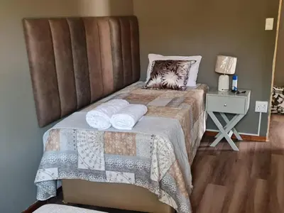a bedroom with a bed with two pillows on it at Tshifaro Gardens in Thohoyandou