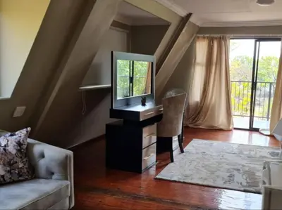 a living room with a tv and a mirror at Tshifaro Gardens in Thohoyandou