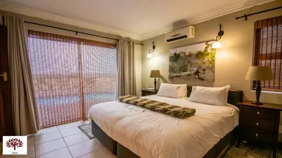 a bedroom with a large bed and a large window at Zebula Golf and Wildlife Estate - Open Plains Pax 10 - Moi Signature Luxury villa in Mabula