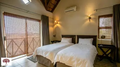 a bedroom with two beds and a large window at Zebula Golf and Wildlife Estate - Open Plains Pax 10 - Moi Signature Luxury villa in Mabula