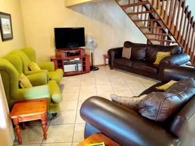 a living room with a couch and a television at Zebula Golf and Wildlife Estate - Njala Crossing Pax 13 - Moi Signature Luxury villa in Mabula
