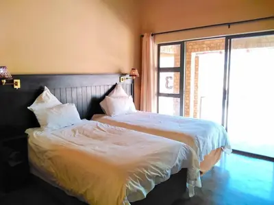 a bedroom with a bed with white sheets and a window at Zebula Golf and Wildlife Estate - Njala Crossing Pax 13 - Moi Signature Luxury villa in Mabula
