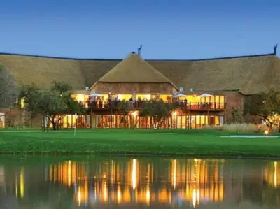 a large building with a reflection in the water at Zebula Golf and Wildlife Estate - Njala Crossing Pax 13 - Moi Signature Luxury villa in Mabula