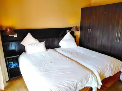 a bedroom with a large bed with white sheets at Zebula Golf and Wildlife Estate - Njala Crossing Pax 13 - Moi Signature Luxury villa in Mabula