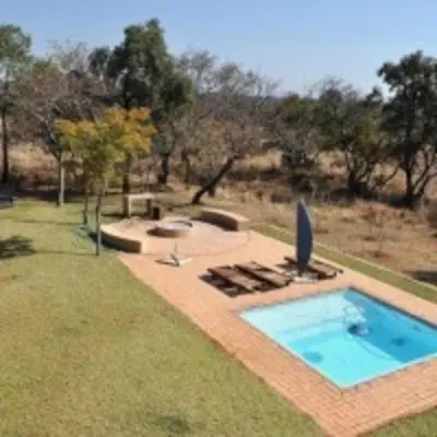 a swimming pool in the middle of a yard at Zebula Golf and Wildlife Estate - Squirrel Pandemonium Pax 12 - Moi Signature Luxury villa in Mabula