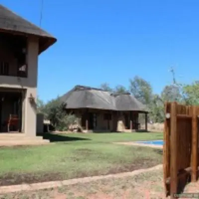a house with a fence in front of it at Zebula Golf and Wildlife Estate - Squirrel Pandemonium Pax 12 - Moi Signature Luxury villa in Mabula