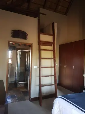 a room with a bunk bed and a ladder at Zebula Golf and Wildlife Estate - Squirrel Pandemonium Pax 12 - Moi Signature Luxury villa in Mabula