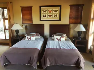 two beds sitting next to each other in a room at Zebula Golf and Wildlife Estate - Squirrel Pandemonium Pax 12 - Moi Signature Luxury villa in Mabula