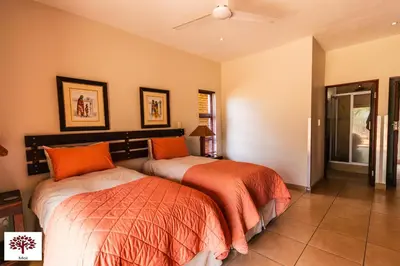 a bedroom with two beds and a ceiling fan at Zebula Golf and Wildlife Estate - Spectacular View Pax 13 - Moi Signature Luxury villa in Mabula
