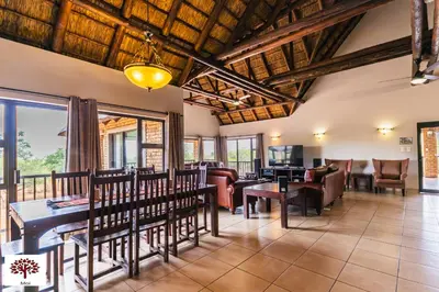 a dining room with wooden ceilings and tables and chairs at Zebula Golf and Wildlife Estate - Spectacular View Pax 13 - Moi Signature Luxury villa in Mabula