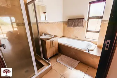 a bathroom with a tub and a sink at Zebula Golf and Wildlife Estate - Spectacular View Pax 13 - Moi Signature Luxury villa in Mabula