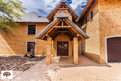 a brick house with a wooden entry door at Zebula Golf and Wildlife Estate - Spectacular View Pax 13 - Moi Signature Luxury villa in Mabula