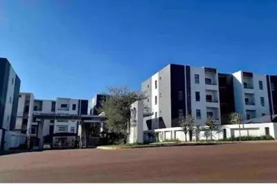 a group of white buildings with a street in front at Blest5 Tranquil Stay in Midrand