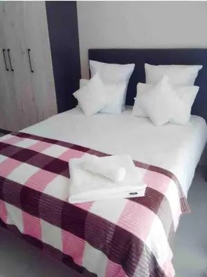 a bed with two white towels on top of it at Blest5 Tranquil Stay in Midrand