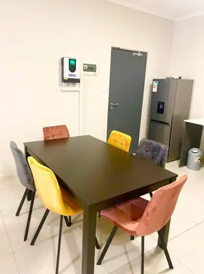 a black table with colorful chairs in a room at Blest5 Tranquil Stay in Midrand