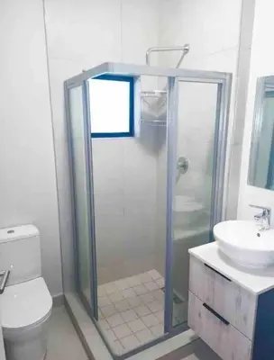a bathroom with a shower and a toilet and a sink at Blest5 Tranquil Stay in Midrand