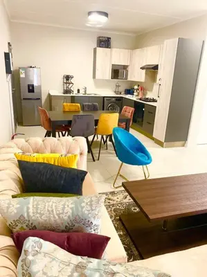 a living room with a couch and a kitchen at Blest5 Tranquil Stay in Midrand