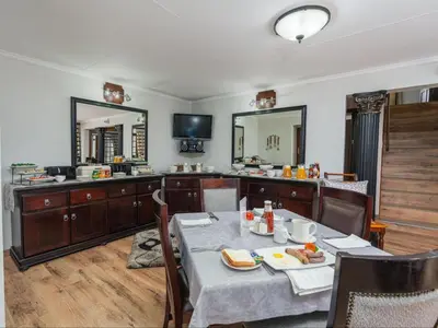 a dining room with a table with food on it at Kuiersaam Guesthouse Luxurious & Mordern Accommodation in Secunda