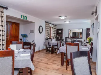 a restaurant with tables and chairs and a dining room at Kuiersaam Guesthouse Luxurious & Mordern Accommodation in Secunda
