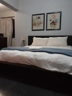 a bedroom with a large bed with two pictures on the wall at The Concept in Centurion