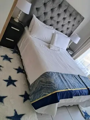 a bedroom with a large bed with a gray headboard at The Blyde Crystal Lagoon in Pretoria